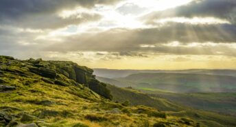 the sun shines through the clouds over the mountains