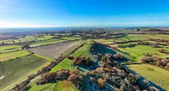 rolling green hills and fields under a clear blue sky