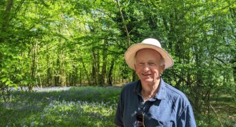 man standing in a wooded glade with bluebells