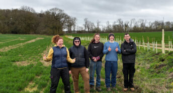 five young people with the hedgerow that they have just finished planting