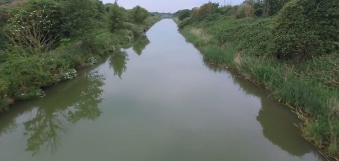 A canal with dense vegetation on either site